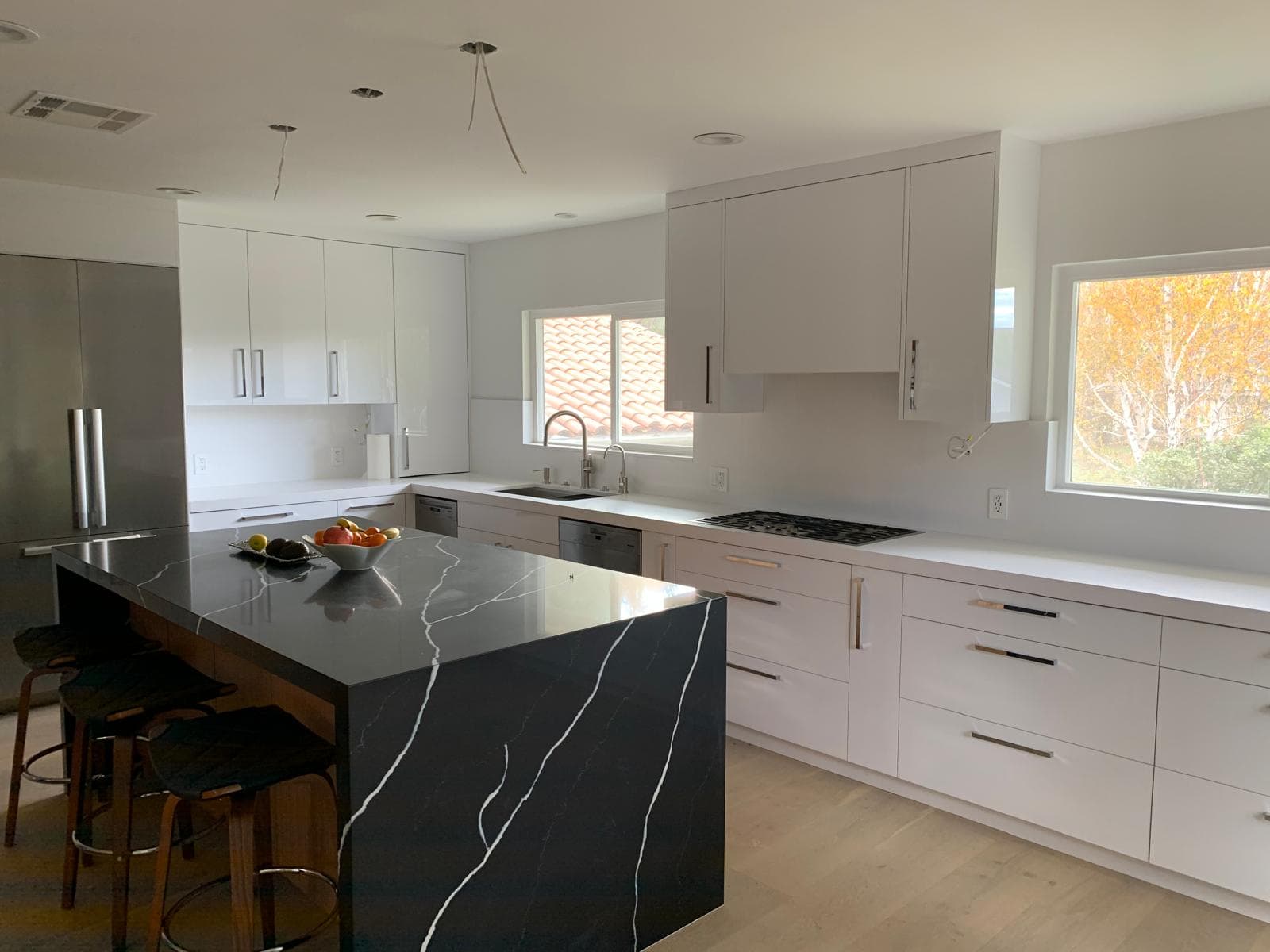 Modern white kitchen with black marble island after installation